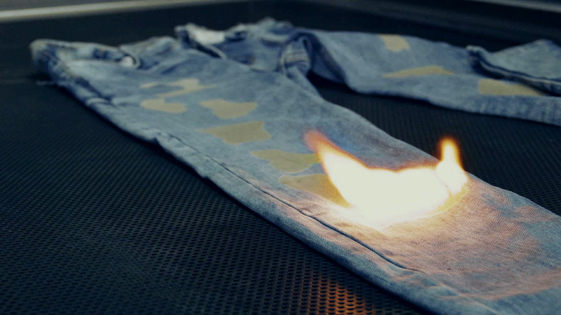 A laser finishing pass burning a fade into denim