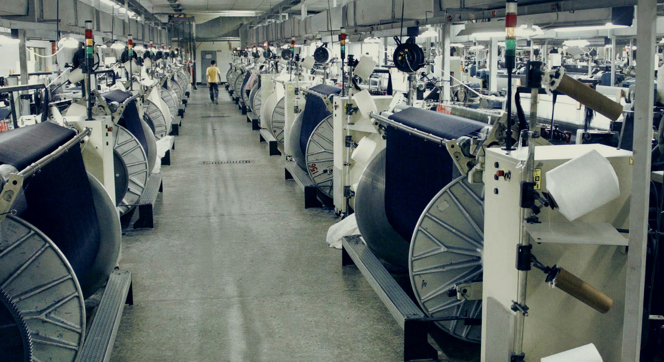 Long rows of looms weaving indigo denim